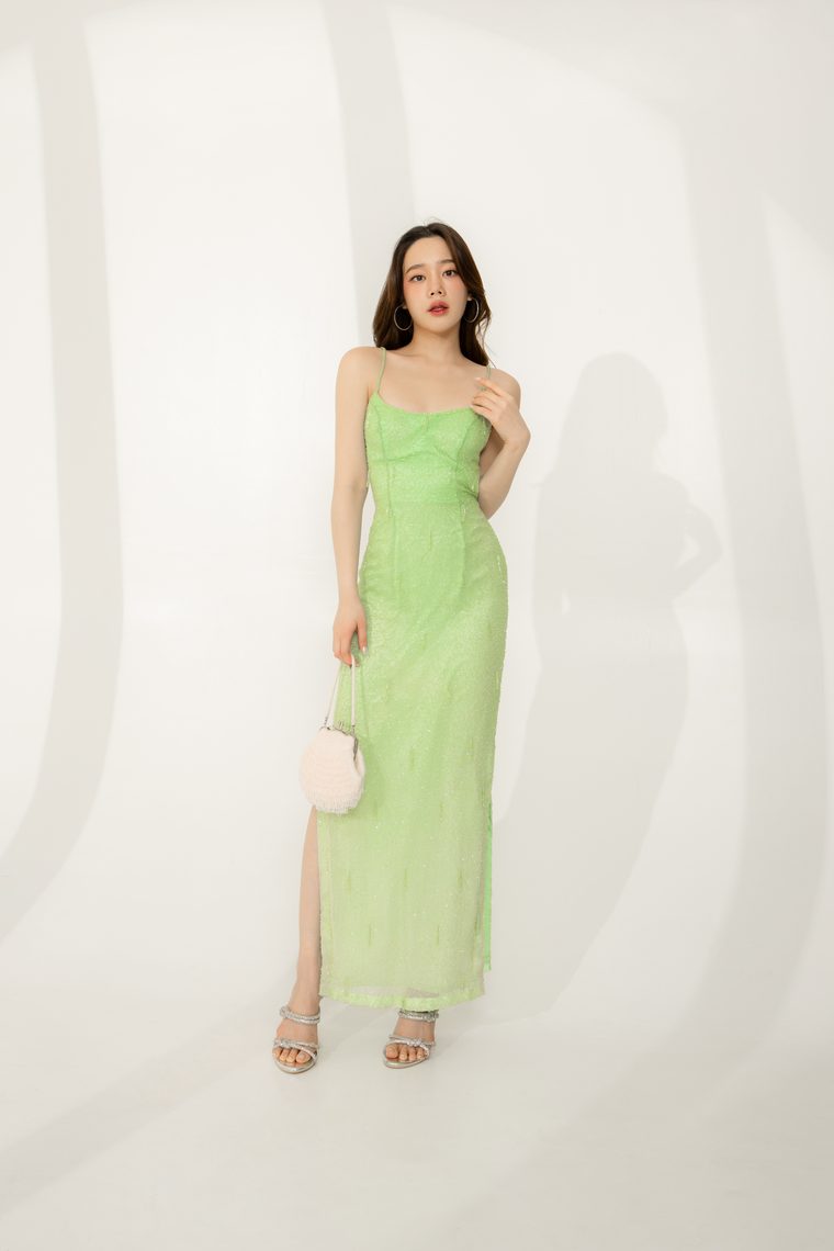 Model in a beaded green vintage slip gown, full length